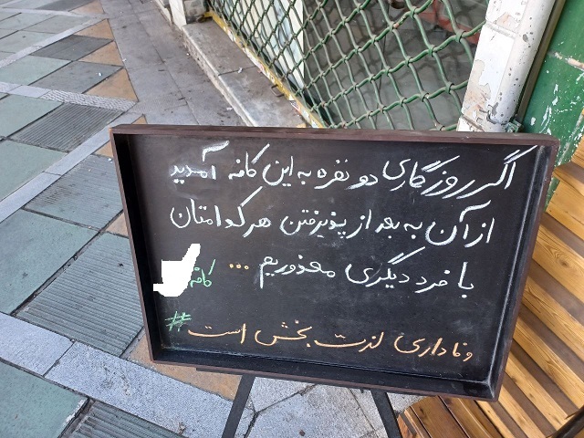 عکسی از نوشته عاشقانه روی تابلوی جلوی یک کافه