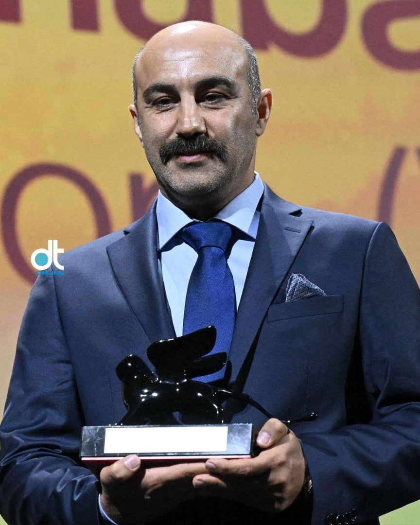 محسن تنابنده، جایزه به دست و با کراوات آبی